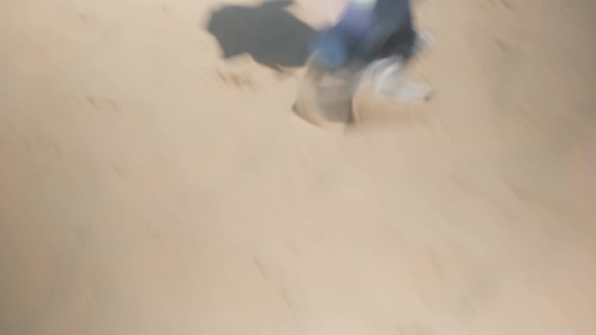 The person walks in the sand