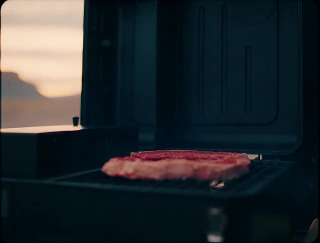 A man throws meat on the grill