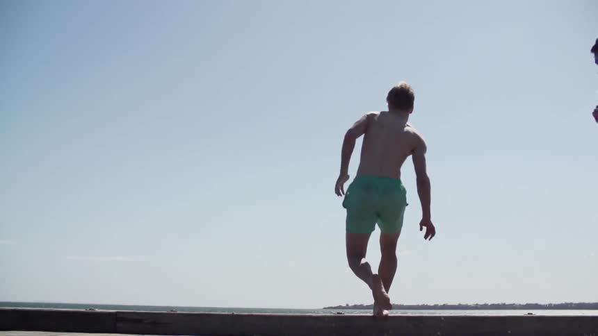 Man running and jumping off of a dock