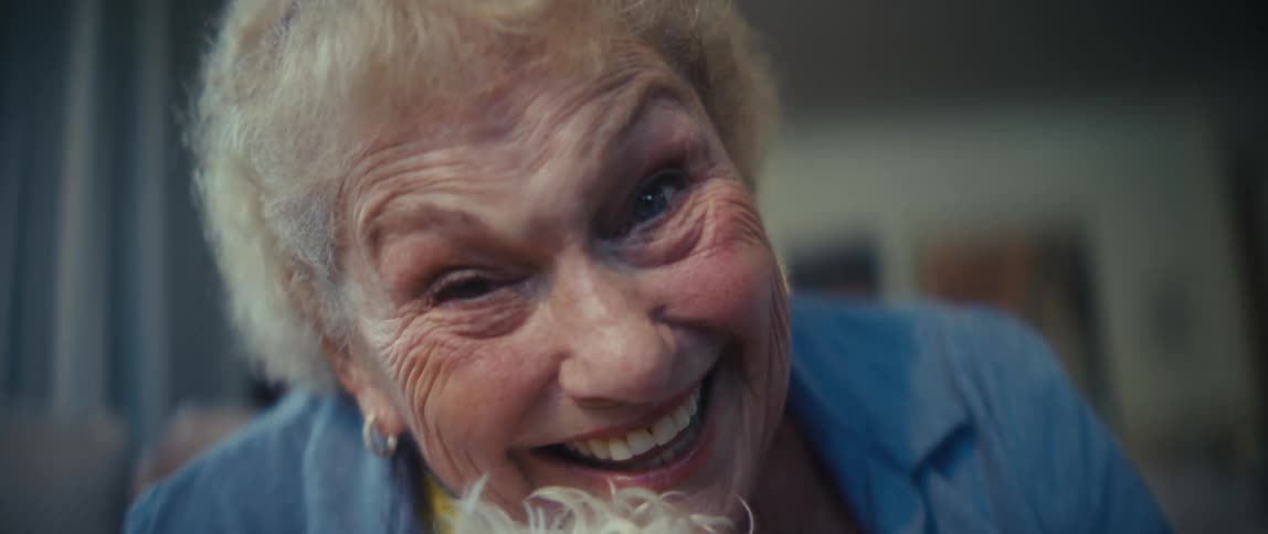 Elderly woman smiling while holding a lighthaired dog in her arms