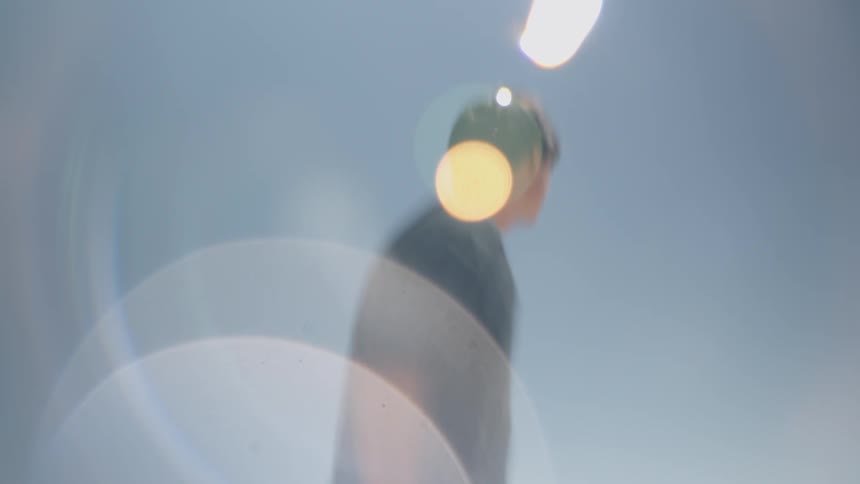 Blurred person looking upward under a clear blue sky