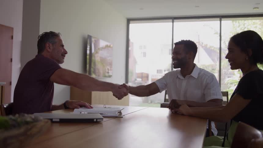 Two men shake hands at the table