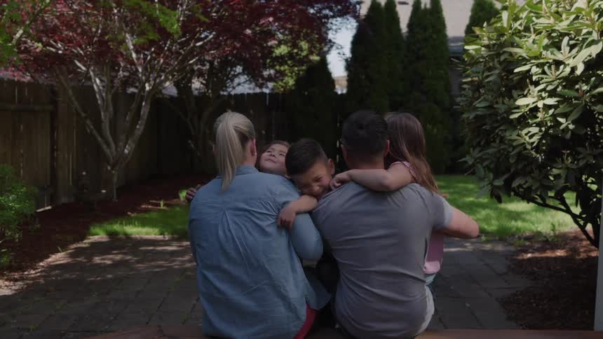 The family are hugging in the hard