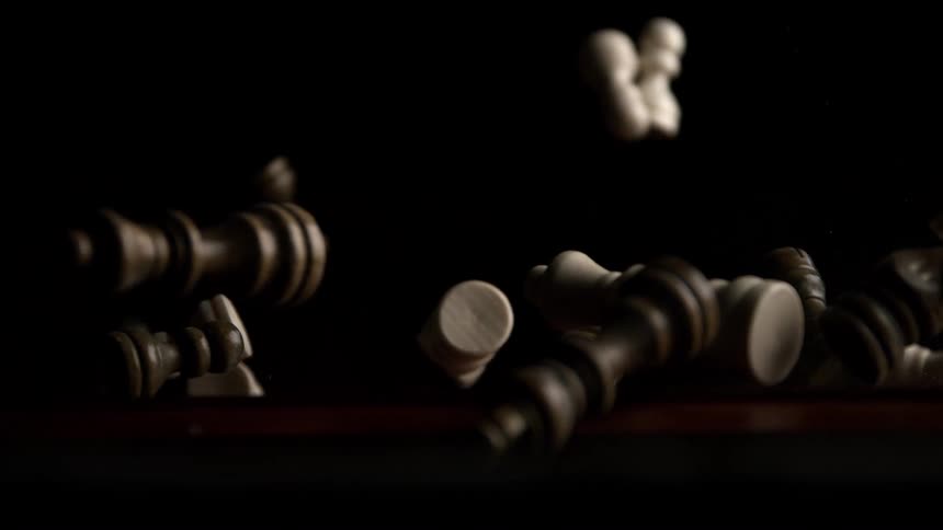 Chess pieces falling onto the table against a dark background