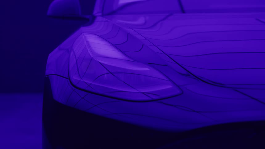 A close stylized view shows the headlight of a car with contour lines fading from a bright amber color to a dark blue glow against a purple background