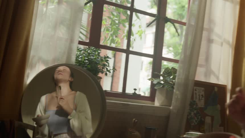 Mirror reflects a woman dancing while she eats during the daytime