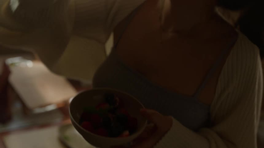 Woman dances while eating fruit in her bedroom