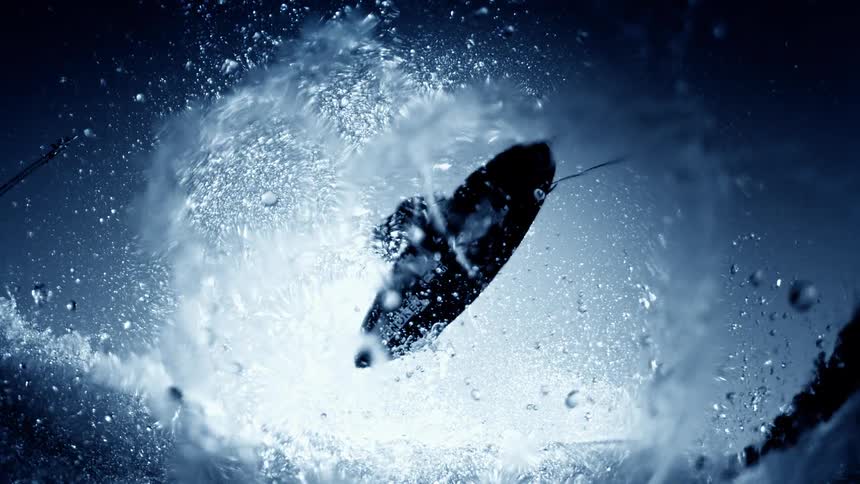Surfboard tossed into the air amid splashes of blue water