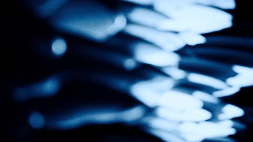 Rows of surfboards stacked horizontally under blue lighting