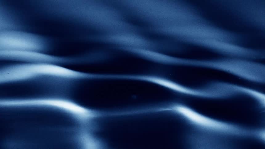 A view of dark blue rippling water with soft highlights