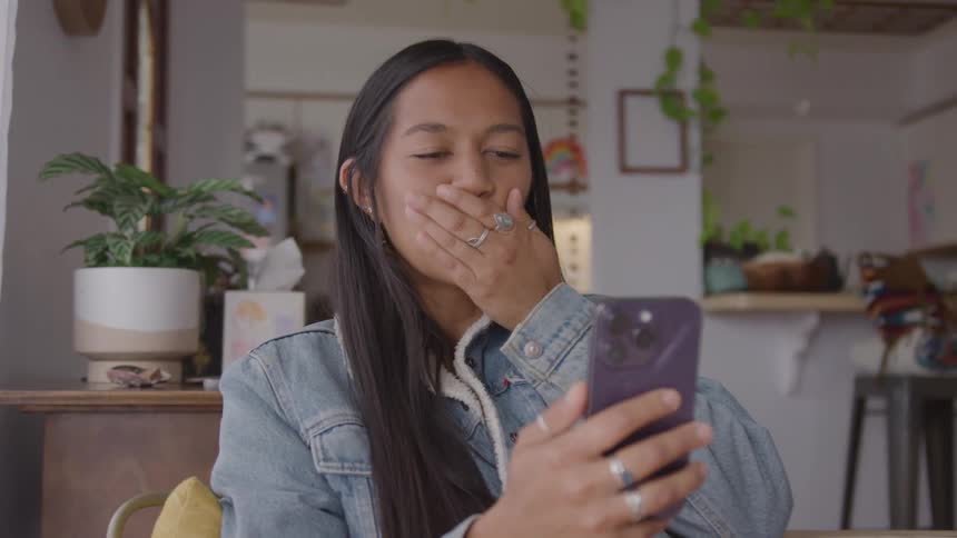 Woman smiling while blowing a kiss during a video call
