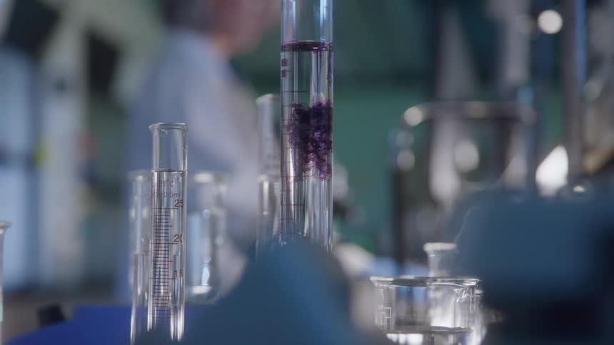 Graduated cylinders with clear liquid placed on a laboratory bench during measurement