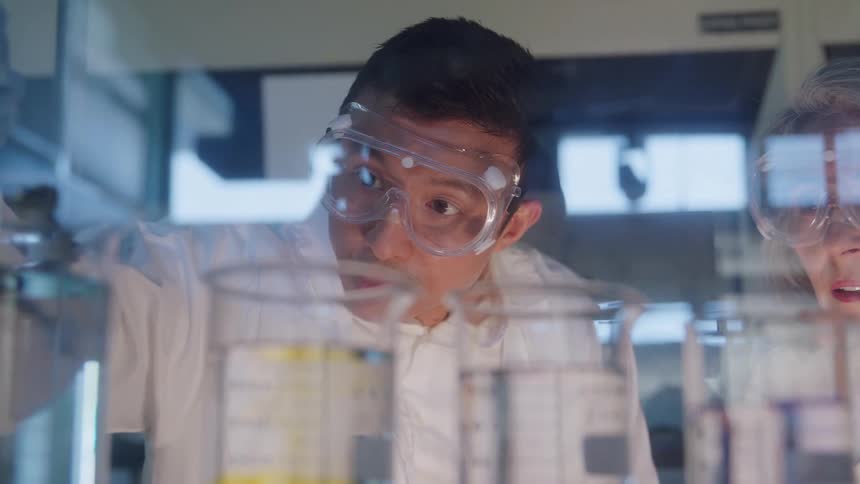 Two scientists closely observing test tubes with colorful liquids in the laboratory