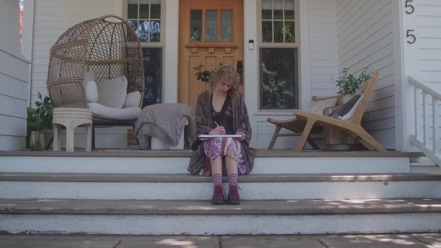 A woman sits on her front porch