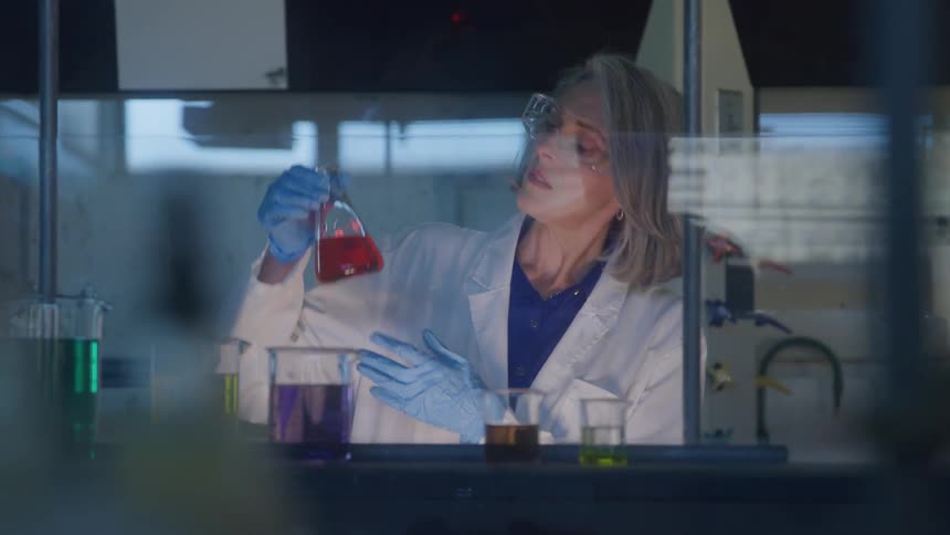 Scientist holding a flask with red liquid in a laboratory