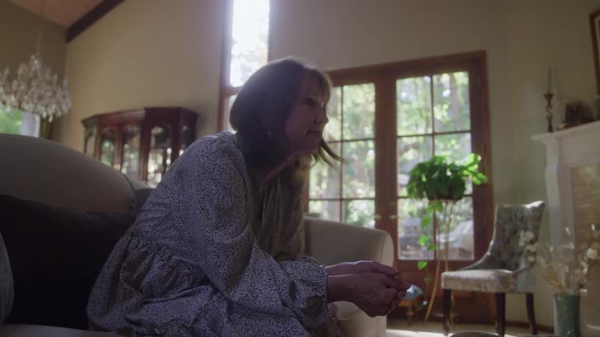 A woman sits on a sofa