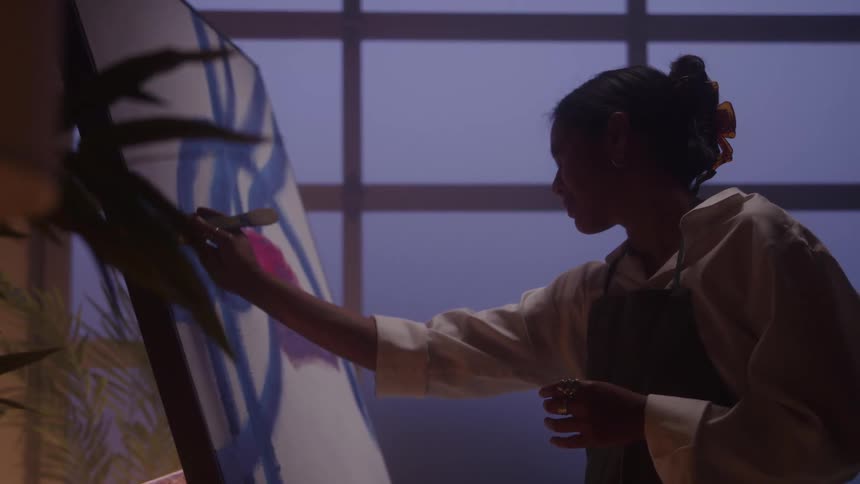 The woman is painting with a small brush