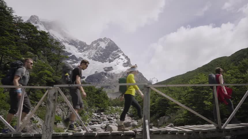 People walk over a small bridge