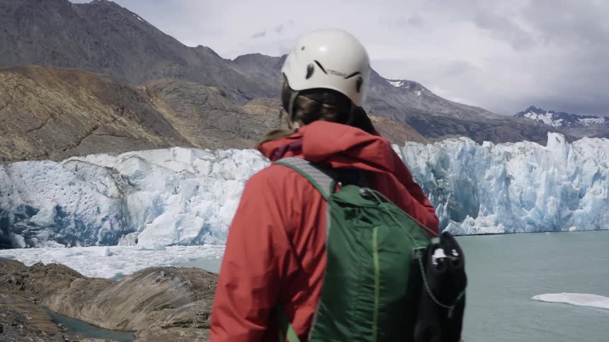 A man is hiking near an ice wall