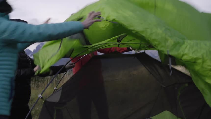 Campers set up a tent in the mountains