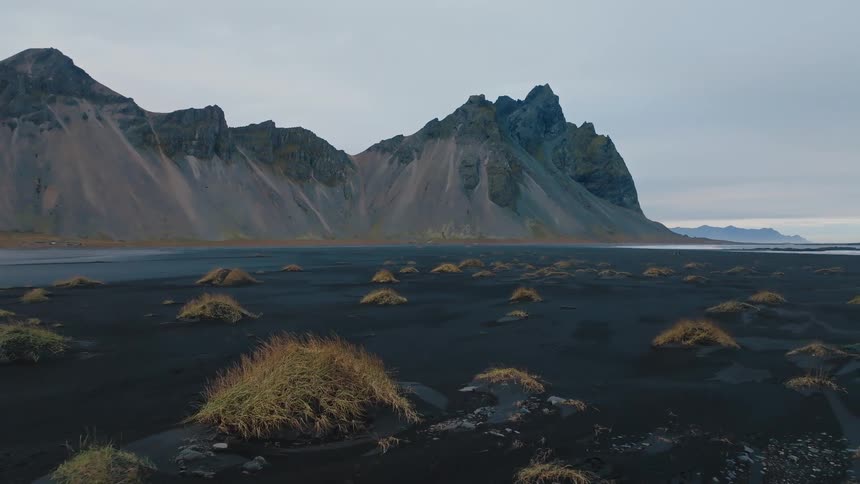 Mountains line the shore on a cloudy day
