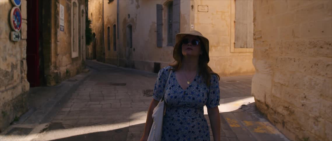 The tourists looks around at the old buildings while walking in the alley