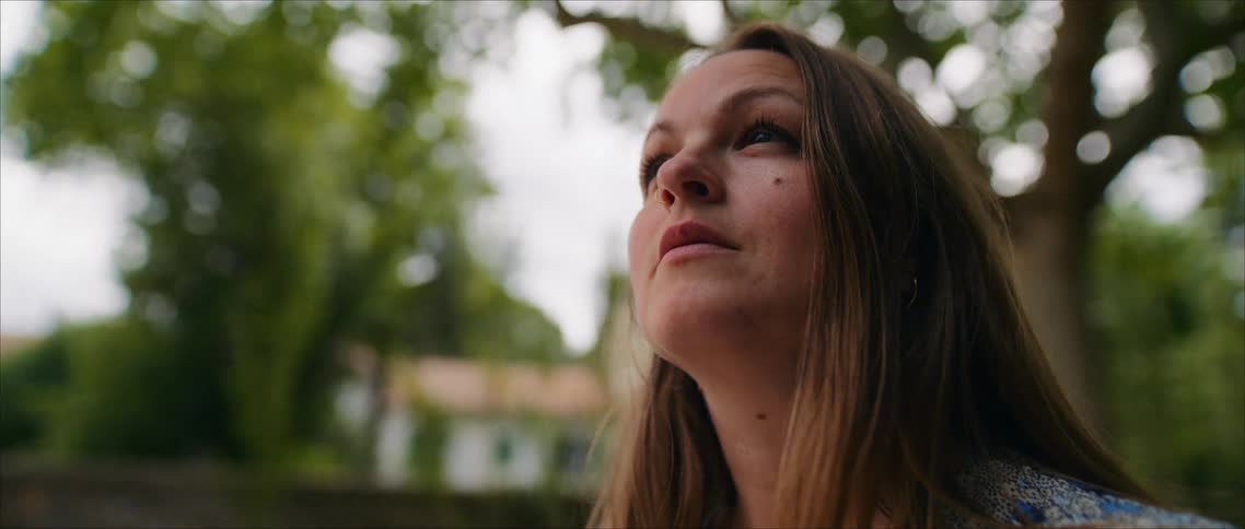 A woman outside looks up