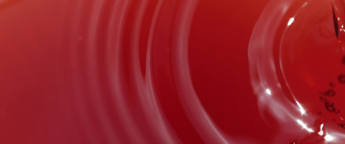 Close up of a red liquid poured into a container