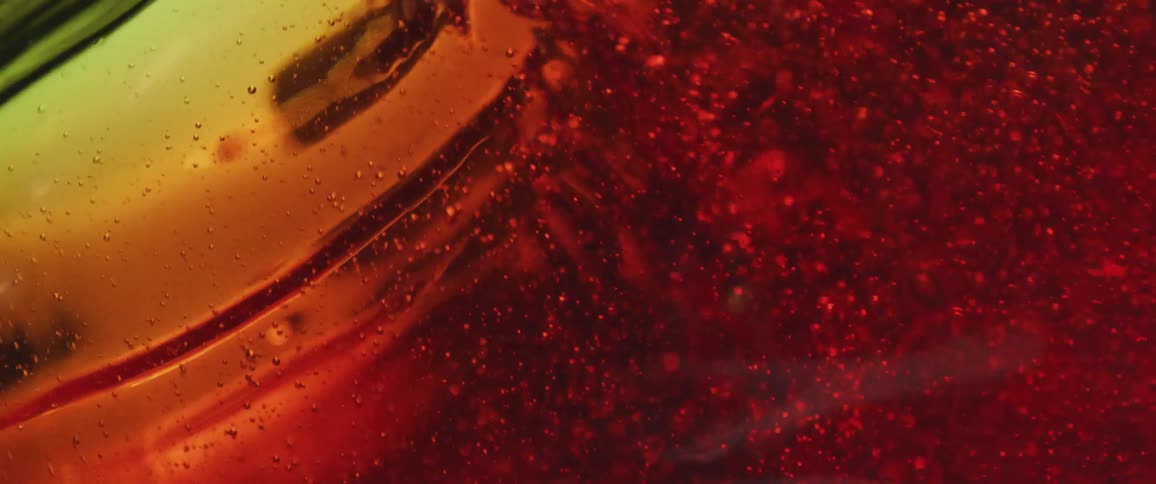 Effervescent amber drink being poured in motion