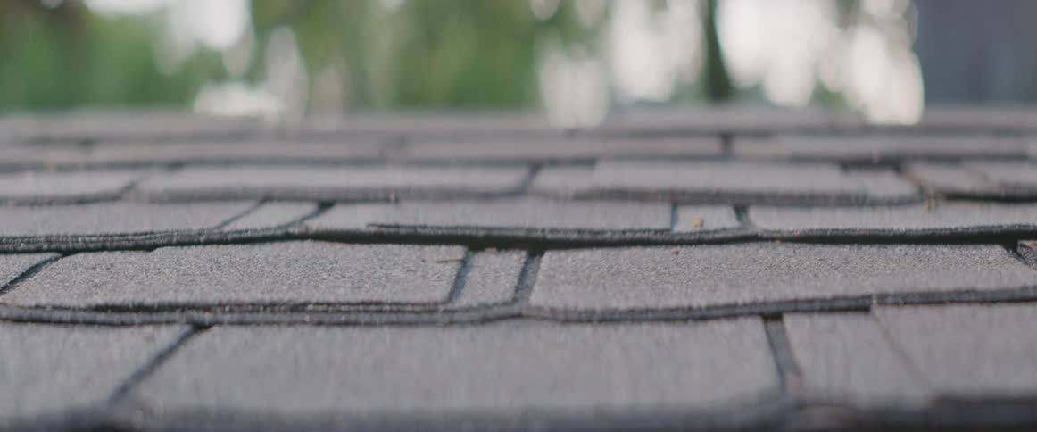 Heat of the day creates a heat haze just above a shingled roof on a summer day