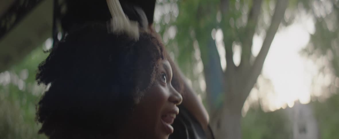 A young female student celebrates by tossing her graduation cap into the air
