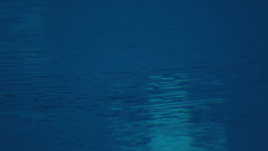 A dark blue expanse of water with gentle ripples and a soft light reflection near the foreground