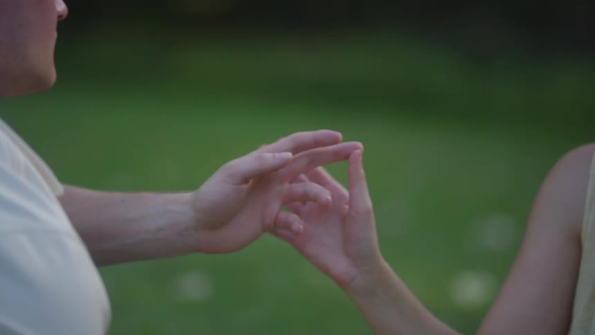 Closeup of a couple embracing and holding hands outdoors