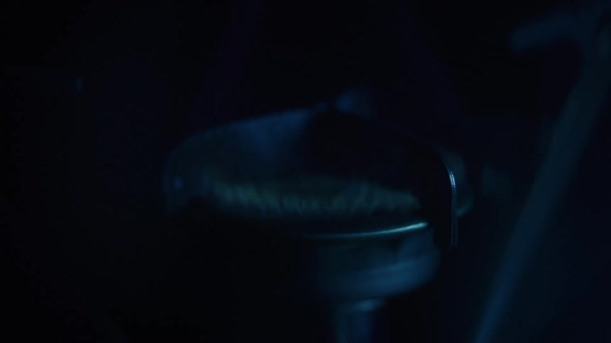 Subtle blue flame heats the metallic center of a burner