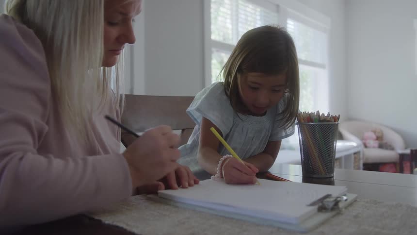 Mother and daughter drawing on a pad with colored pencils