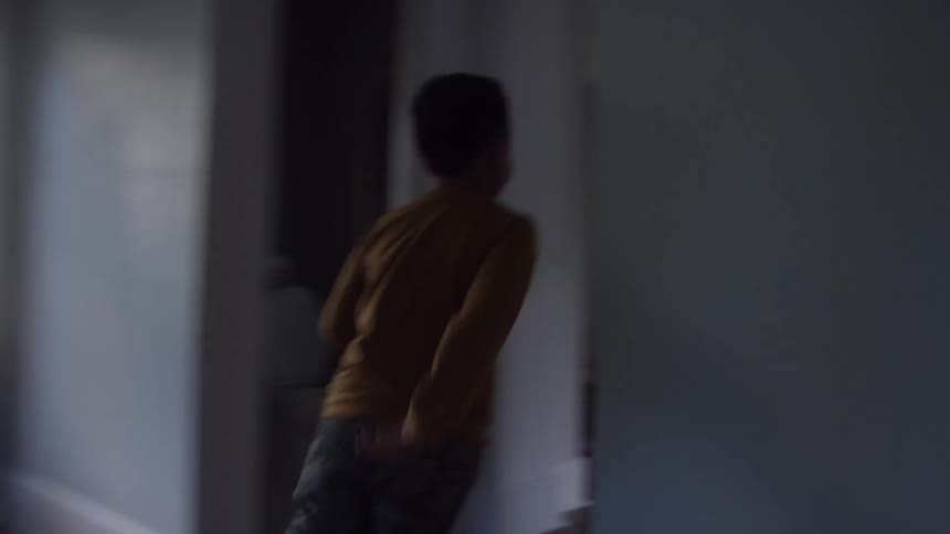 A male child runs through corridors at home during daytime to meet his dad seating in the living room