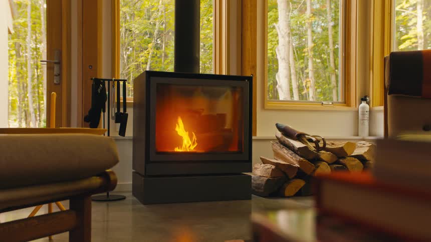 Fire burning in a wood burning stove in a cabin in the woods
