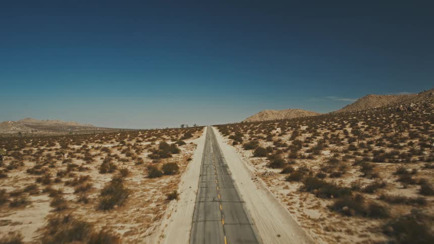 Aerial of a remote highway in a desert on a sunny day