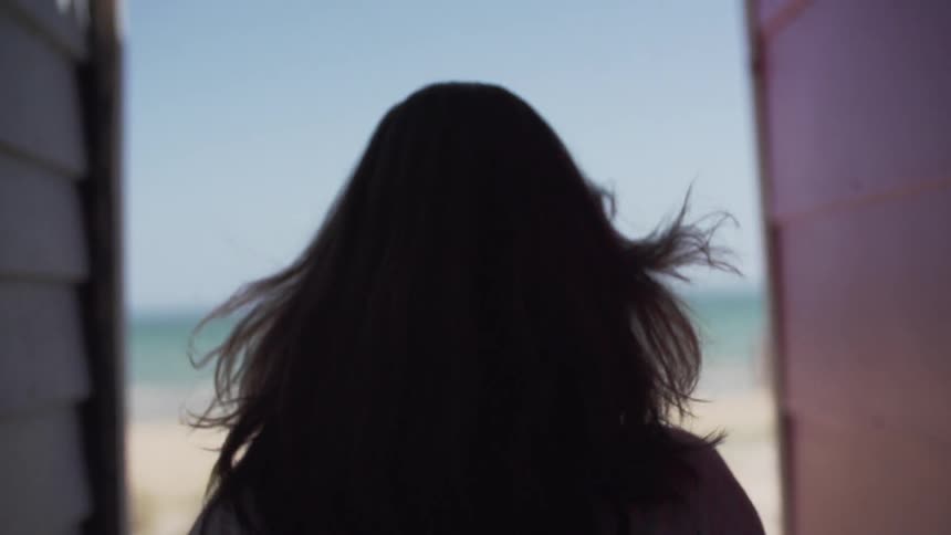 Woman walking towards a beach