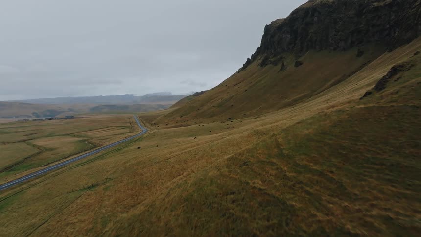Mountains lead down to a road