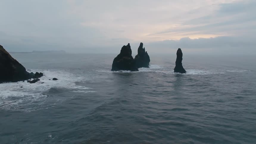 Waves crash along the cliffside