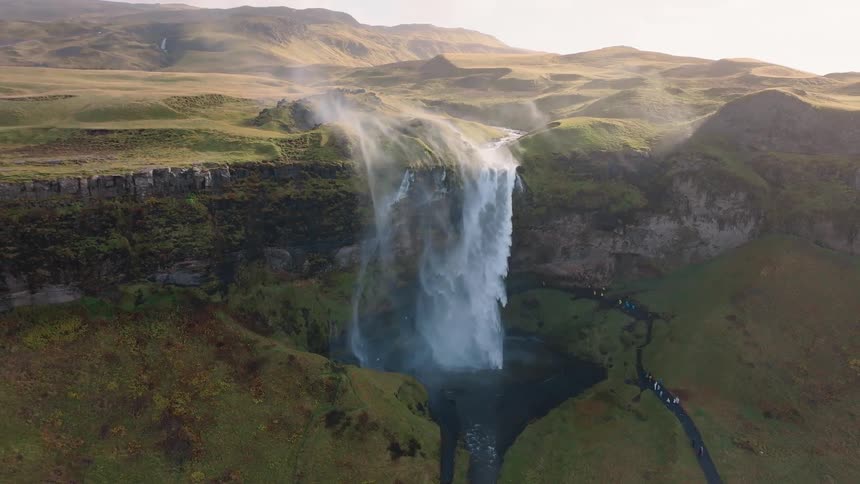The waterfall pours into the spring