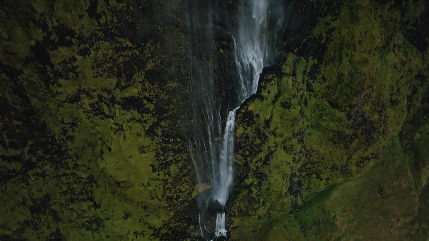 Waterfall cascading down a mosscovered cliff