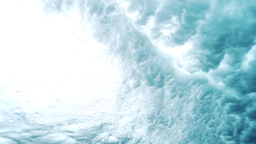 Foam clouds move underwater after the wave crashes
