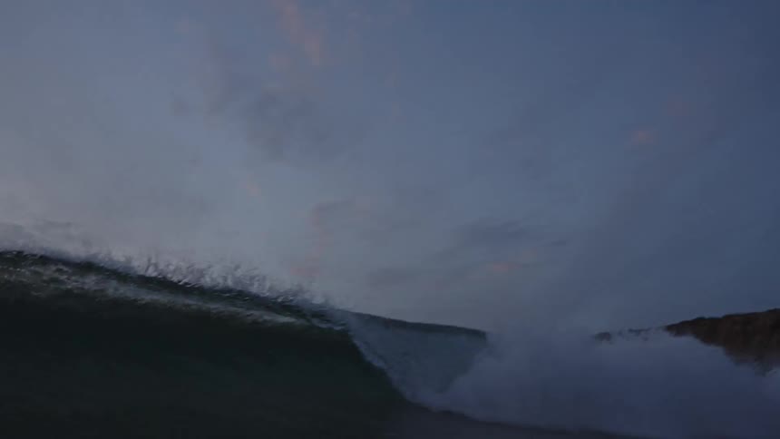 A wave crashes over the camera
