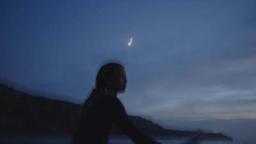 Slow shutter - surfer watching the sea at dusk under the moonlight