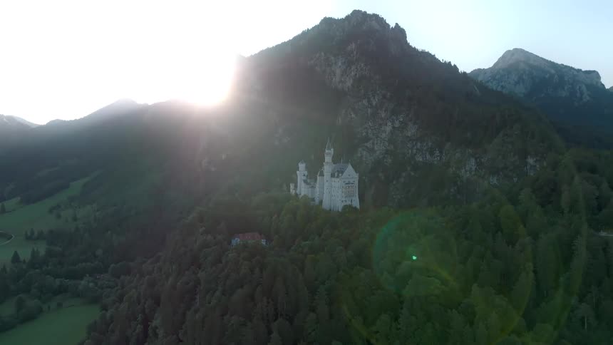 Aerial of a remote castle nestled on the hillside in the mountains