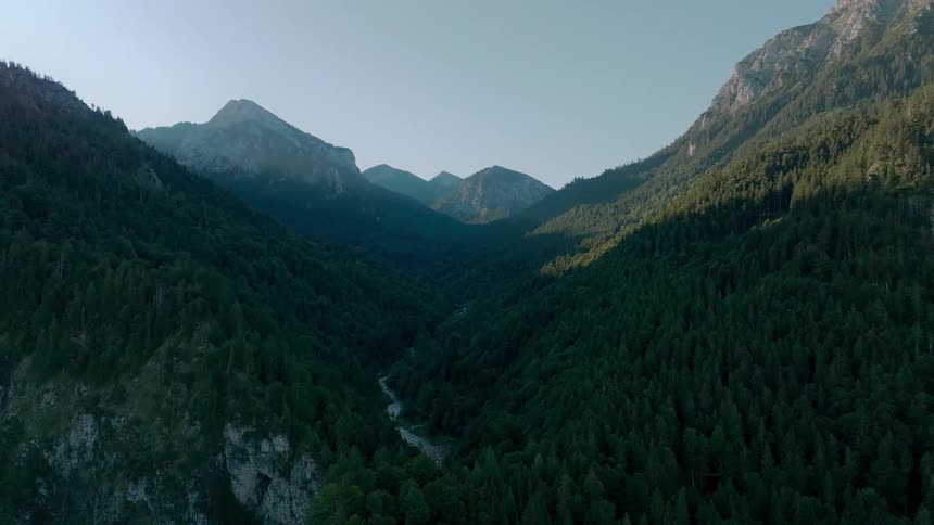 River runs between forested mountains on a foggy day