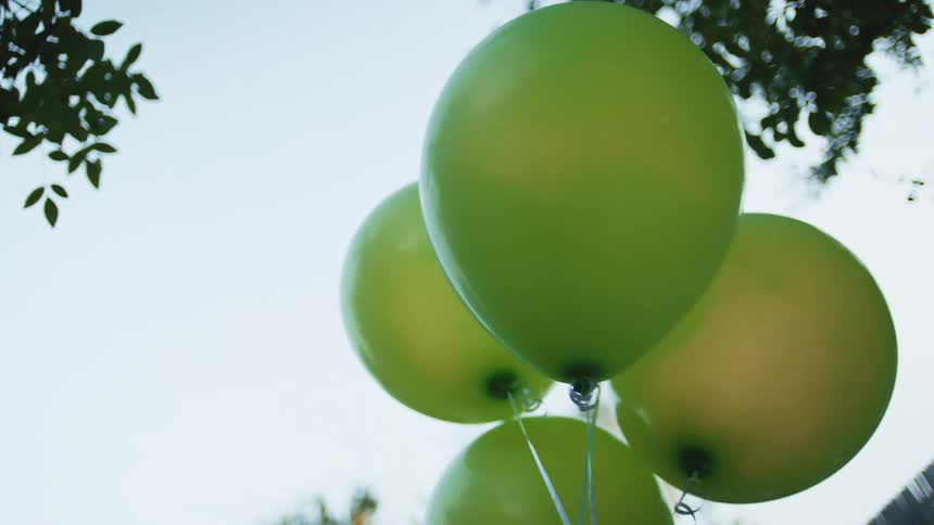 Green balloons float outside
