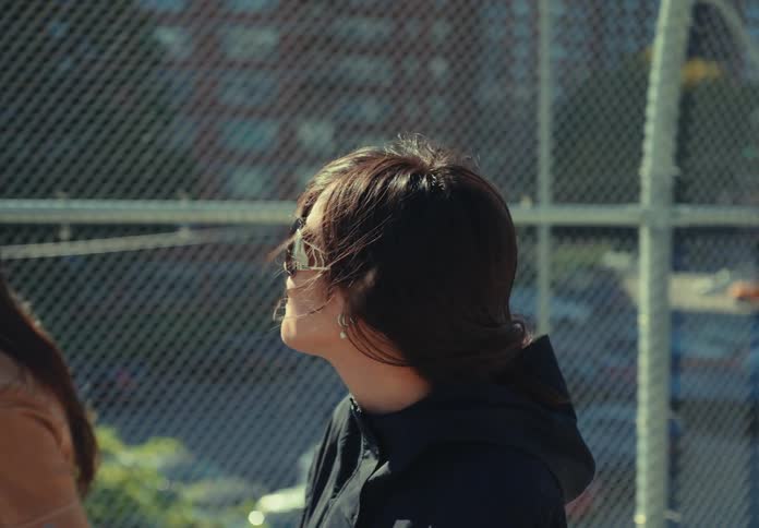 Two women walking down the street one of them wearing sunglasses and smiling